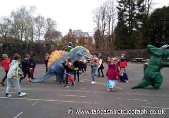 Roaring success as inflatable dinosaurs surprise primary school on Red Nose Day