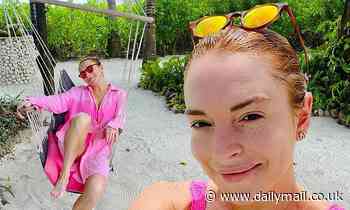 Lindsay Lohan is pretty in pink swimsuit before adding a coverup to swing in a hammock - Daily Mail