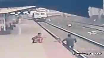See moment child is saved from oncoming train