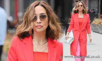 Myleene Klass is a vision in red and pink as she makes her grand entrance at Global Radio Studios