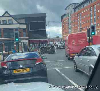 Vehicle flipped onto side and another goes into side of estate agents in Bolton