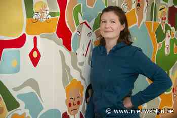 Stephanie zet filmposter op wand van bistro