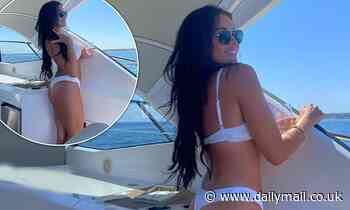 Jess Wright puts on a cheeky display in a thong bikini as she lounges on a boat