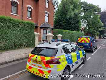 Police vehicles outside set of flats in Blackburn