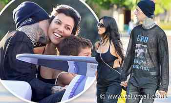 Travis Barker nuzzles Kourtney Kardashian's neck as the couple pack on the PDA at Disneyland