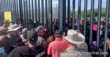 Hundreds of Immigrants Amass at Texas Border Wall, Attempt to Force Their Way Through Gate