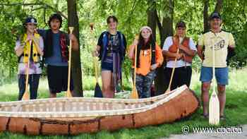 Indigenous students paddle handmade birch bark canoe on Speed River