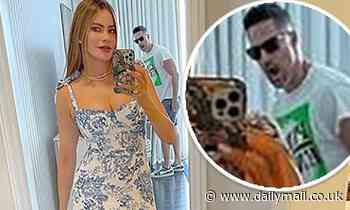 Sofia Vergara snaps a stunning selfie while husband Joe Manganiello checks her out in the background - Daily Mail