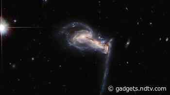 Hubble Space Telescope Spots Gravitational Tug-of-War Among Trio of Galactic Siblings