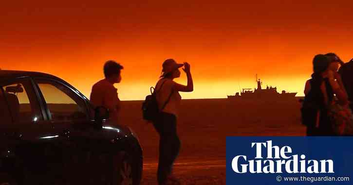 Sky glows red over ferry evacuating people from Greek island fire – video