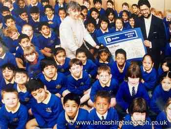 Smiling faces as firm donates money to Blackburn school for new computers