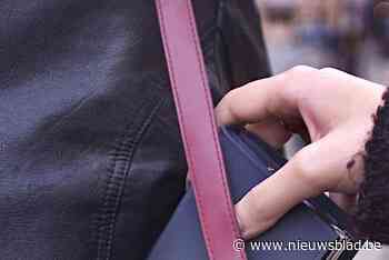 Gauwdief grist portemonnee uit handtas van vrouwelijke shopper