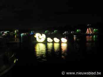 Verlichte boten varen in de duisternis over de Maas