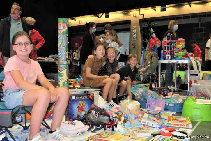 Kinderen verkopen speelgoed op rommelmarkt