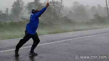 Reporter struggles to hold wind gauge to storm