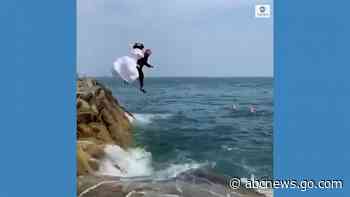 WATCH:  Bride and groom dive into the ocean in wedding outfits