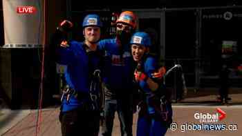 Global News Morning’s Blake Lough and Dallas Flexhaug rappel Sheraton Calgary Eau Claire for charity