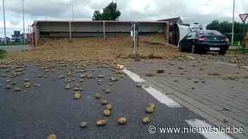 Vrachtwagen kantelt op rotonde, aardappelen rollen over auto