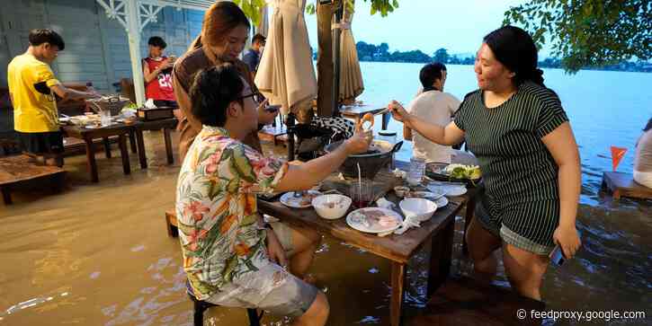 Flooded Thai restaurant becomes a hit with local diners, who dodge waves from passing boats while eating their meals