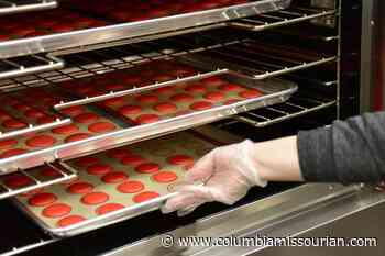 Mackenzie Blakeman takes cookies out of the oven - Columbia Missourian