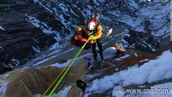Rescuers save dangling BASE jumper after he slammed into a cliff and his parachute got stuck on a rock