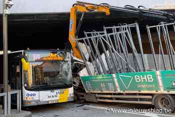 Vrachtwagen met kraan botst tegen brug Mechelen-Nekkerspoel en kantelt tegen bus