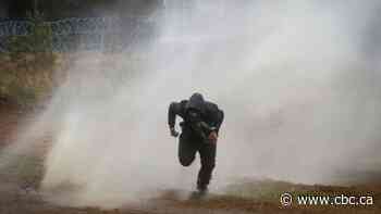 Polish forces use water cannons on stone-throwing migrants at Belarus border