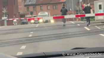Slagbomen blijven dicht maar vrouw met kind op de arm steekt toch spoorweg over