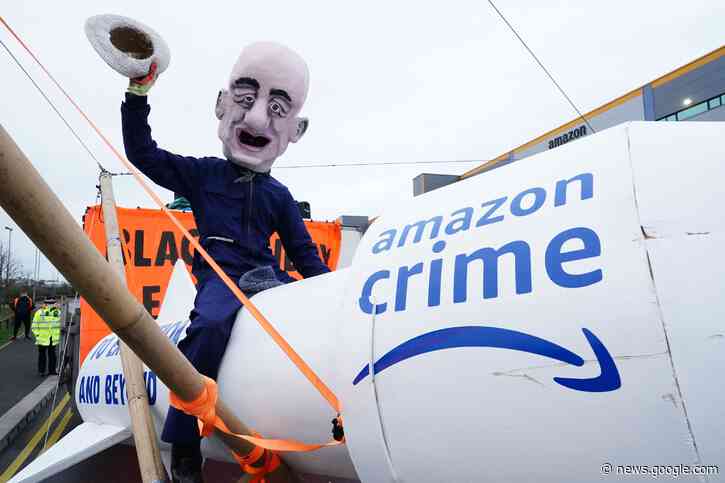 Black Friday protests: Jeff Bezos caricature rides rocket as Extinction Rebellion block 15 Amazon depots - The indy100