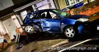 Speeding car crashes into parked vehicles before taking out a wall - Grimsby Live