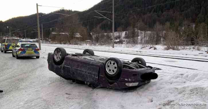 Mann schiebt falsch geparktes Auto mit Traktor weg