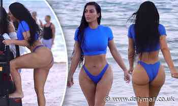 Kim Kardashian showcases her famous hourglass curves in a bright blue bikini crop top and bottoms
