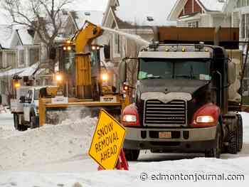 City of Edmonton crews battle ponding water and windrows in an effort to clear residential streets