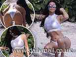 Kim Kardashian shows off her taut tummy and famous derriere in silver bikini