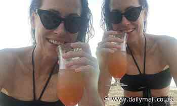 Minnie Driver shows off her youthful figure in a black bikini while on holiday in Barbados