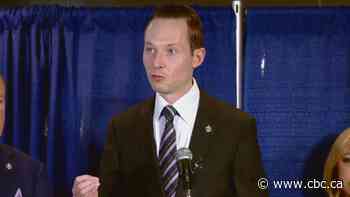 Edmonton-area MP under fire for photo of him near flag bearing Nazi symbol