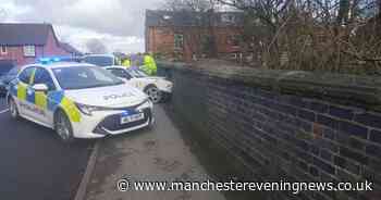 Dramatic pictures show car teetering after smashing through Bolton bridge - Manchester Evening News