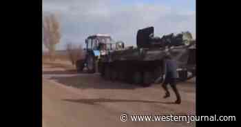 Video Shows Man Desperately Running After Russian Armored Vehicle Being Towed Away by Ukrainian Tractor - Report