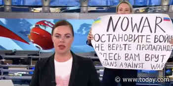 Russian TV employee holds up a sign saying 'No War' during country’s news broadcast