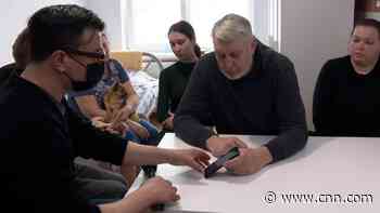 Ukrainian refugee shows CNN pictures of their destroyed home