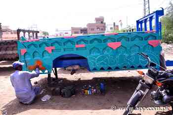A painter busy painting on the trolley at his workplace - Associated Press of Pakistan