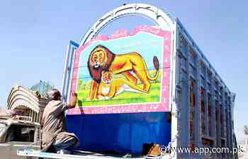 A painter busy in painting the body of a delivery truck at his workplace at Pirwadhai neighbourhood - Associated Press of Pakistan