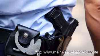 Mann richtet Spielzeugwaffe auf Polizisten