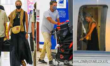 Lachlan Murdoch pushes suitcases through Sydney airport after arriving with wife Sarah and children - Daily Mail
