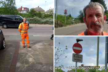 Man stands in bus lane blocking cars near A41 roundabout