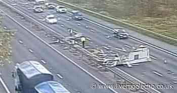 Queues on M56 after caravan flips over in middle of motorway