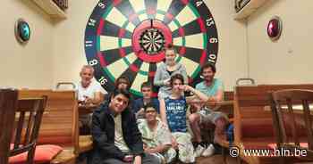 Leerlingen De Karwij schilderen levensgroot dartsbord op muur café De Retour - Het Laatste Nieuws