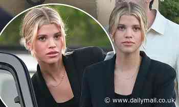 Sofia Richie layers up in a black overcoat while having dinner with her fiance and friends in Malibu