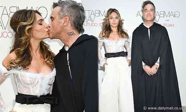 Robbie Williams dons dramatic black cloak as he kisses wife Ayda Field during Paris Fashion Week - Daily Mail