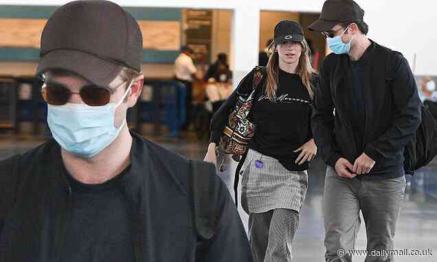 Robert Pattinson and girlfriend Suki Waterhouse match trousers as pair are spotted at JFK - Daily Mail
